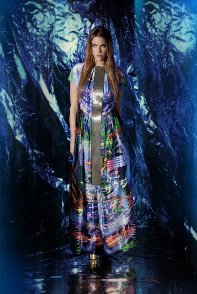 Long thobe-style silk dress in blues with neon green and yellow city name calligraphy in Arabic and Japanese, featuring a 4-inch silver beaded panel down the center.